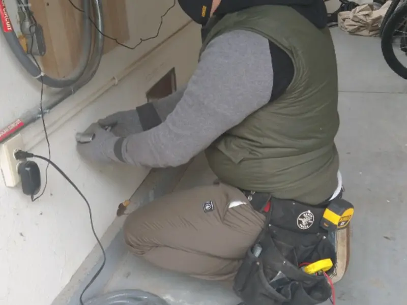 Electrician performing outlet wiring in a Germantown garage